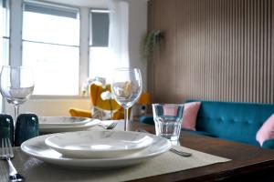 a table with plates and glasses on top of it at Falkirk City Centre Stylish Two-Bedrooms Apartment in Falkirk
