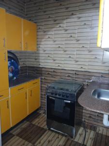 una cocina con estufa y fregadero en Hamada guest house, en Asuán