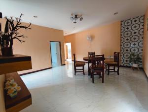 a dining room and living room with a table and chairs at Patcharin house in Ko Lanta Yai