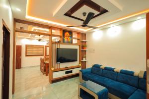 a living room with a blue couch and a flat screen tv at Wayanadan Huts Homestay in Sultan Bathery
