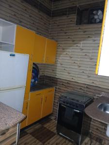 cocina pequeña con armarios amarillos y fogones en Hamada guest house, en Asuán 10 fotos más