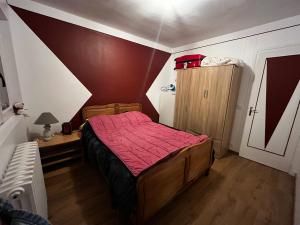 a small bedroom with a bed with a red blanket at Maison de plain pied - 120m2 - Location cure ou vacances in Bagnoles de l'Orne