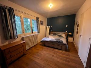 a bedroom with a bed and a large window at Maison de plain pied - 120m2 - Location cure ou vacances in Bagnoles de l'Orne