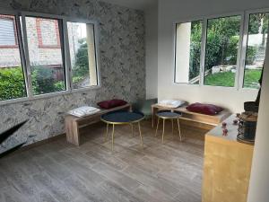 a room with two tables and two chairs and windows at Maison de plain pied - 120m2 - Location cure ou vacances in Bagnoles de l'Orne