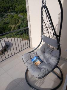 a swing chair with a book in it on a balcony at Apartman Lasko 1 in Goveđari +2 photos