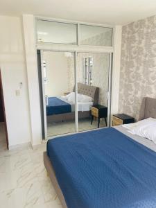 Un dormitorio con una gran cama azul y un espejo. en perfect villa, en Punta Cana 9 fotos más