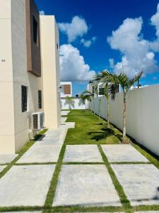 Una pasarela junto a un edificio blanco con palmeras. en perfect villa, en Punta Cana
