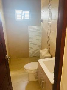 Un baño con un inodoro blanco y un lavabo. en perfect villa, en Punta Cana