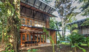 une maison dans la forêt avec une table et des chaises dans l'établissement Porto Alegre Resort, à Punta Uva