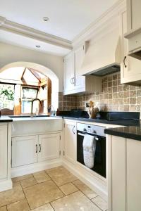 a kitchen with white cabinets and a sink at Characterful holiday home in Oxfordshire Cotswolds  +45 photos