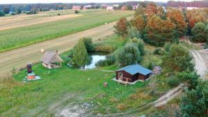 an aerial view of a farm with a cabin and a pond at Chata U Pawlaka in Krasne