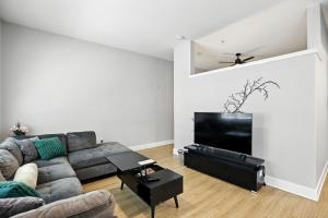 a living room with a couch and a flat screen tv at Towson Elite Apartment in Towson