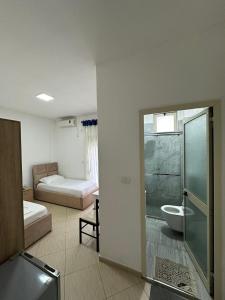 Habitación con 2 camas y baño con ducha. en Amarildo Rooms, en Durrës
