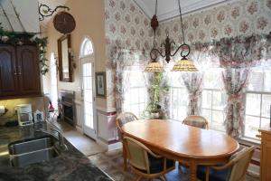 a kitchen with a wooden table and some windows at Copeland Castle in Greensboro