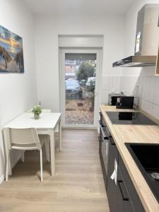 cocina con mesa, mesa blanca y mesa en City-Apartment - zentral mit schöner Terrasse, en Herne