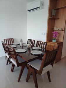 a dining room table with four chairs and a wooden table and chairsktop at Sunrise Apartments in San Felipe de Puerto Plata