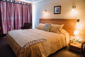 a bedroom with a large bed and a chair at Hotel Chalet Valluga in Farellones +71 photos