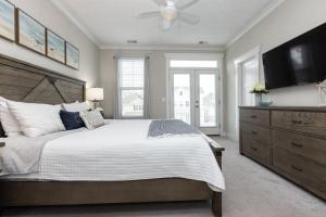 a bedroom with a large bed and a flat screen tv at 525 The Back Bay House in Virginia Beach