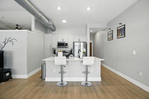 a kitchen with white cabinets and a counter with stools at Towson Elite Apartment in Towson +5 photos