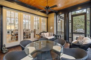 un porche cubierto con mesa de cristal y sillas en SS162: 162 Surfsong Road, en Kiawah Island