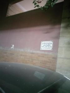 a car parked in front of a wall with a sign at Ali in Cairo
