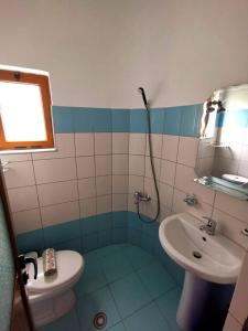 une salle de bain avec un lavabo et des toilettes dans l'établissement Hotel Continental, à Ksamil