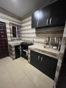 una cucina con armadi neri e stufa nera di Dersym Apartment a Port Harcourt