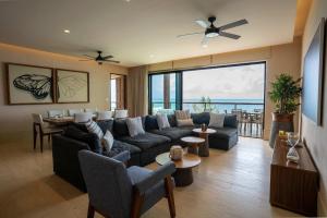 a living room with a couch and a dining room at 3BR Beachfront Elegant Condo -Family Getaway in Isla Mujeres