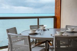 a table and chairs with a view of the ocean at 3BR Beachfront Elegant Condo -Family Getaway in Isla Mujeres +53 photos