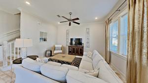 a living room with white furniture and a ceiling fan at Prominence 30A - Holiday House in Watersound Beach
