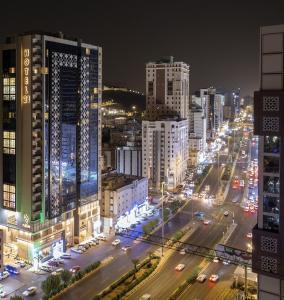 a city skyline at night with traffic on a street at Hotel 21 Makkah in Makkah