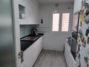 a kitchen with white cabinets and a sink and a window at Room next to Gibraltar in La Línea de la Concepción