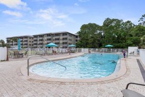 a swimming pool with people playing in it at Happy Days - Seagrove Highlands in Santa Rosa Beach