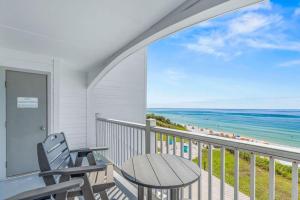 a balcony with a table and a view of the beach at Blue Tide 6B in Inlet Beach