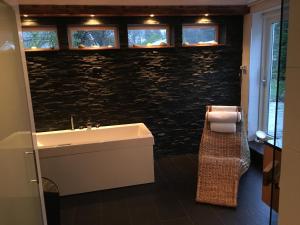 a bathroom with a sink and a stone wall at Harmonious villa with sauna in a quiet area in Järfälla