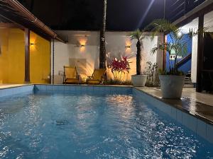 a swimming pool in a house with palm trees at Pousada Acquarela Paraty - SOB NOVA DIREÇÃO!!! in Paraty