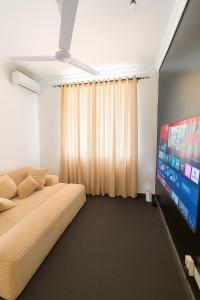 a bedroom with a bed and a flat screen tv at Zurihomes in Dar es Salaam