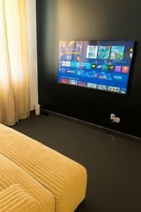 a room with a bed and a flat screen tv at Zurihomes in Dar es Salaam