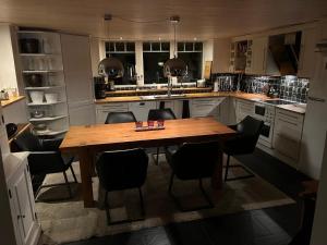 a kitchen with a wooden table and black chairs at Harmonious villa with sauna in a quiet area in Järfälla +12 photos