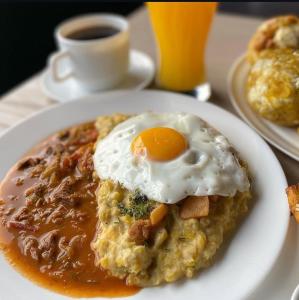 a plate of food with an egg on top of oatmeal at Casa De la Cruz in Quito