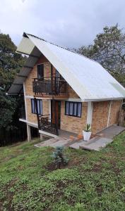 a house with a metal roof and a balcony at Cabaña privada cerca de Armenia Quiet Mountain View Country Home in Salento