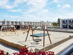 a playground with a swing set in the sand at 8 person holiday home in Glesborg in Glesborg
