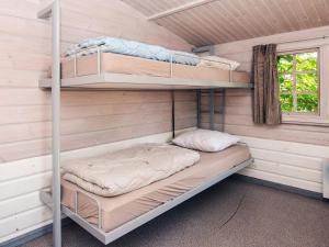a room with two bunk beds in a cabin at Lush cabin in camping resort in Aabenraa