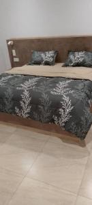a bed with a black and white blanket and pillows at Villa de luxe à Ngaparou Saly center in Mbour