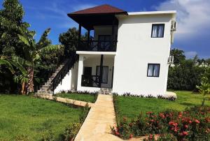 a white house with a pathway leading to it at Villas Reynoso, Near La Playita Beach in Las Galeras Samaná in Las Galeras