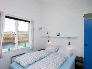 ein Bett in einem Zimmer mit einem Fenster in der Unterkunft 7 person holiday home in Ebeltoft in Ebeltoft + 31 Fotos