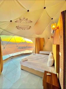 a bedroom in a tent with a bed and a window at Catalina Luxury rum camp in Wadi Rum