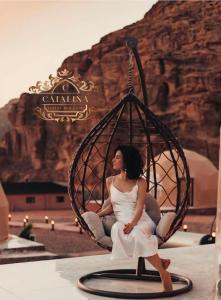 a woman sitting in a swing at a resort at Catalina Luxury rum camp in Wadi Rum