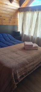a bedroom with a bed with a blanket on it at Al pie del león in Ñirihuau