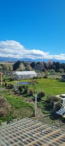 a view of a field with a building in the distance at Al pie del león in Ñirihuau